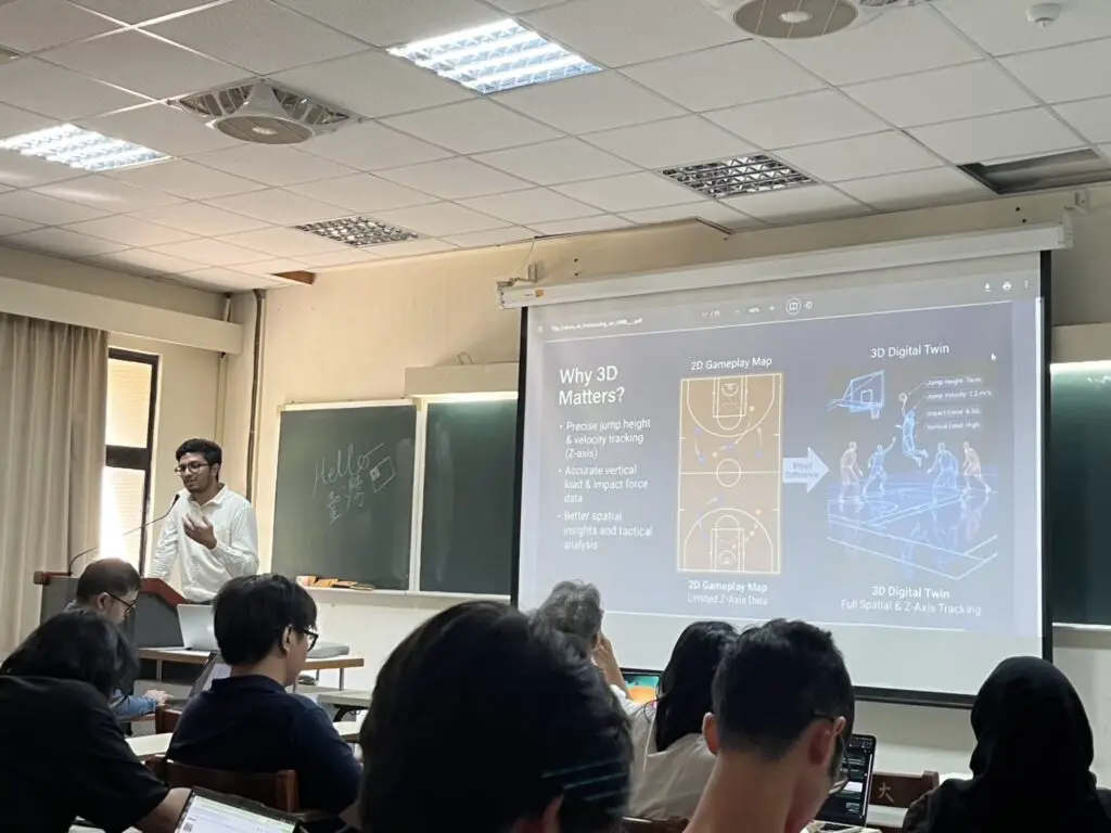 Speaker presenting a slide on 3D digital twin basketball data analytics to a classroom audience.