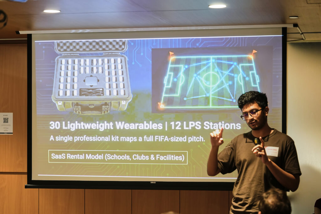 Presenter displaying a slide about sports tech wearables and LPS tracking stations for pitch mapping.